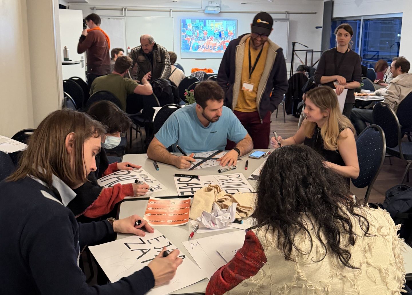 Voluntarios de PauseAI preparando pancartas para una protesta.